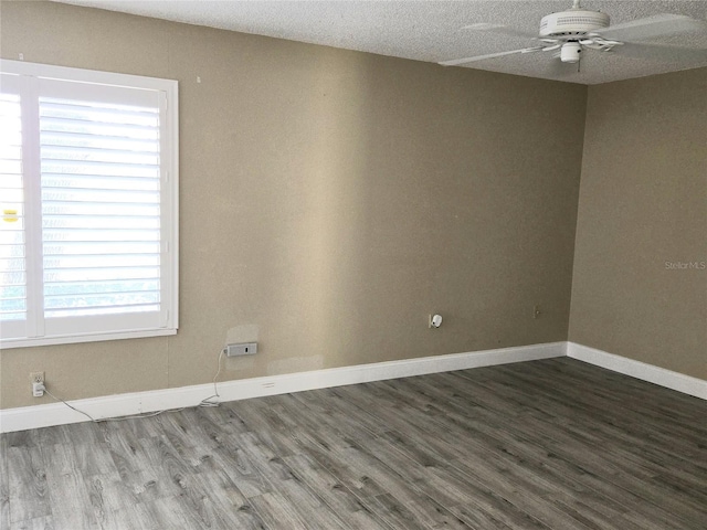 spare room featuring a textured ceiling, baseboards, ceiling fan, and wood finished floors