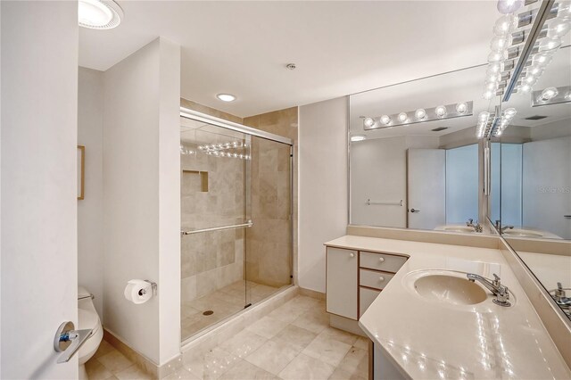 bathroom featuring a shower with door, toilet, tile patterned flooring, and vanity