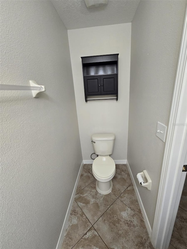 bathroom featuring a textured ceiling and toilet