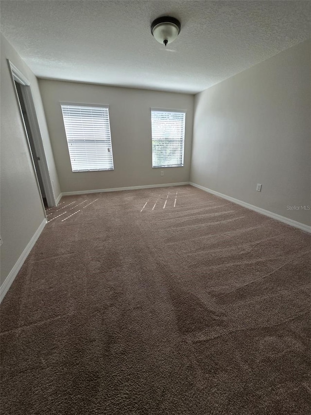 unfurnished room featuring carpet floors and a textured ceiling