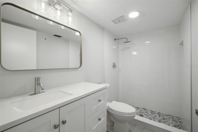 bathroom with tile patterned floors, vanity, toilet, and walk in shower