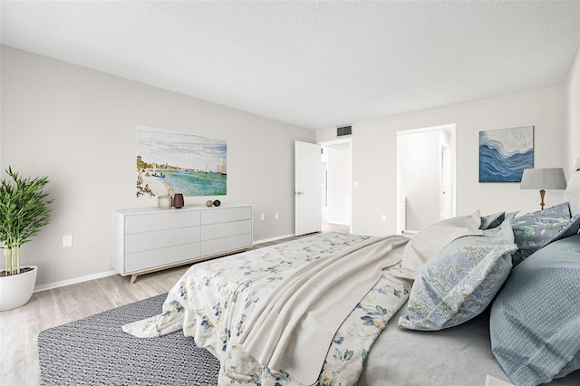 bedroom featuring wood-type flooring and a textured ceiling