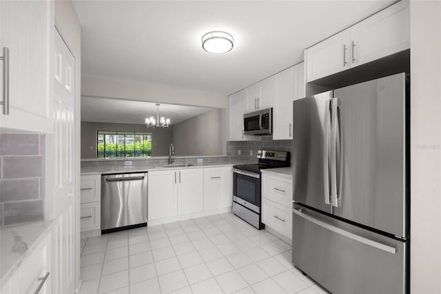 kitchen with an inviting chandelier, white cabinets, sink, tasteful backsplash, and stainless steel appliances