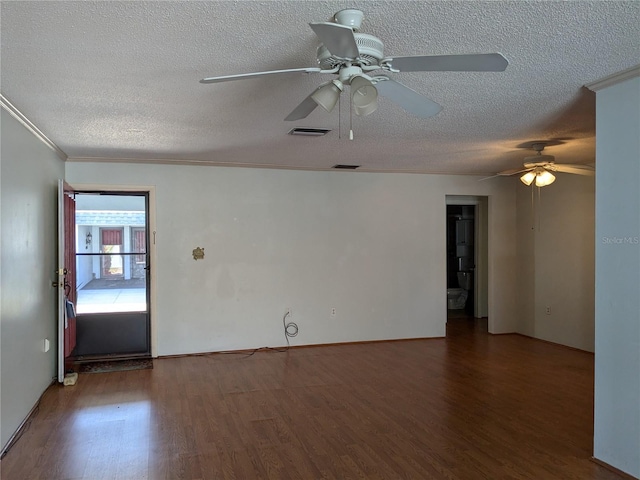 spare room featuring dark wood-type flooring, ornamental molding, and a textured ceiling