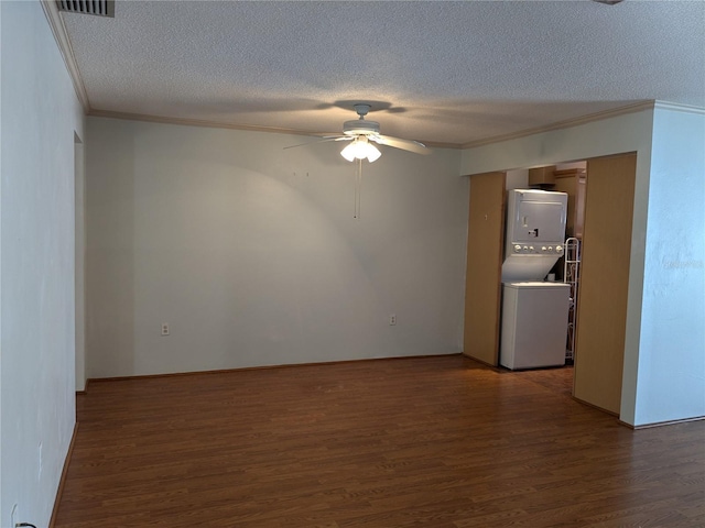 empty room with dark hardwood / wood-style floors, ceiling fan, stacked washing maching and dryer, and a textured ceiling