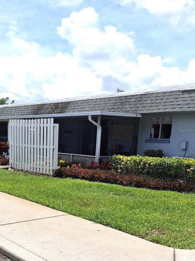 view of side of home with a yard