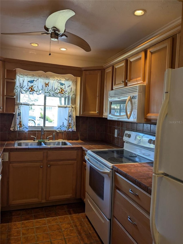 kitchen with tasteful backsplash, white appliances, ceiling fan, and sink