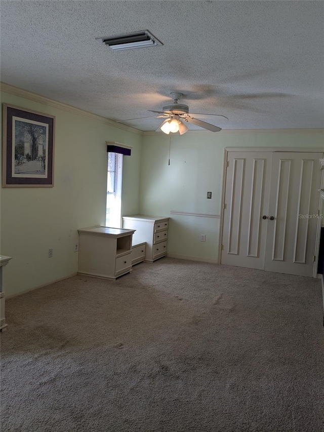 unfurnished bedroom with crown molding, light colored carpet, ceiling fan, and a textured ceiling