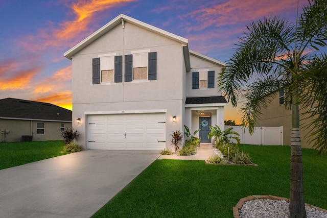 view of property with a garage, central AC unit, and a lawn