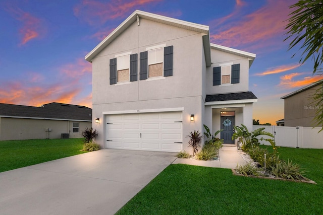 view of front property with a garage, central AC, and a lawn