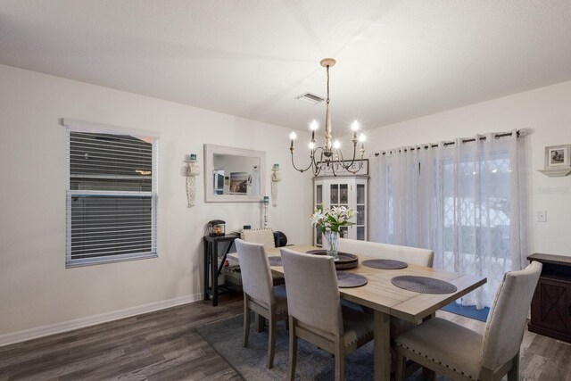 dining space with a chandelier and dark hardwood / wood-style floors