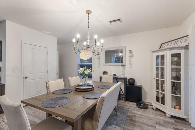 dining area featuring an inviting chandelier and hardwood / wood-style floors