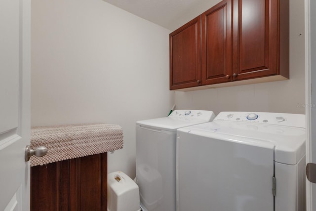 clothes washing area featuring cabinets and washing machine and dryer