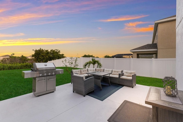 patio terrace at dusk featuring outdoor lounge area, a lawn, and area for grilling