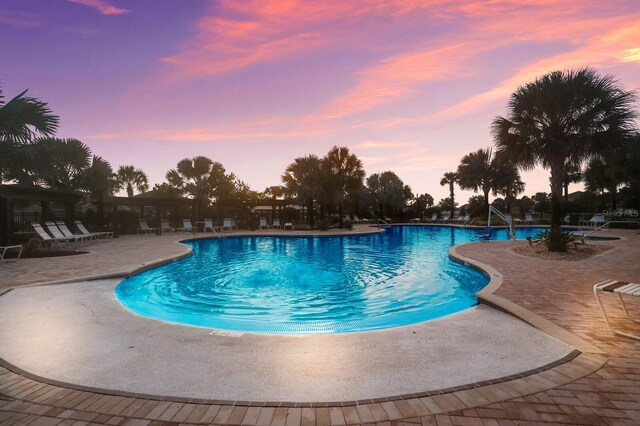 pool at dusk with a patio