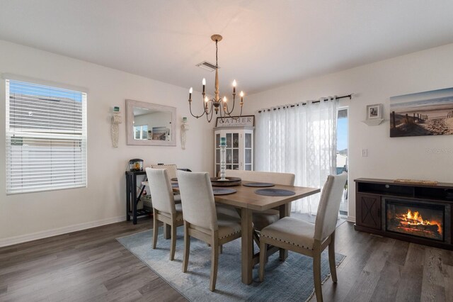 dining room with a notable chandelier and dark hardwood / wood-style flooring