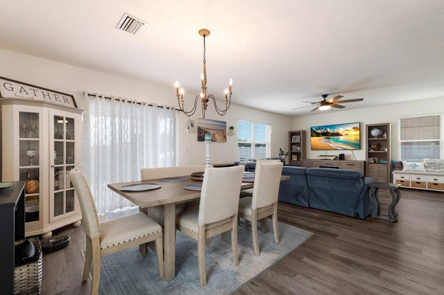 dining room featuring dark wood-type flooring and ceiling fan with notable chandelier