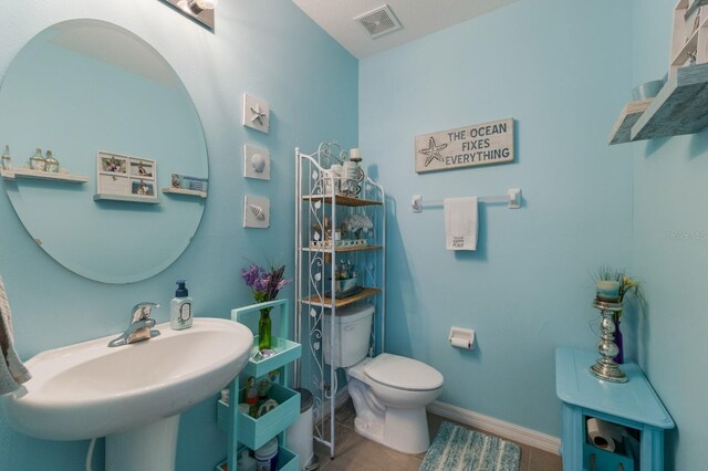 bathroom featuring tile flooring, sink, and toilet