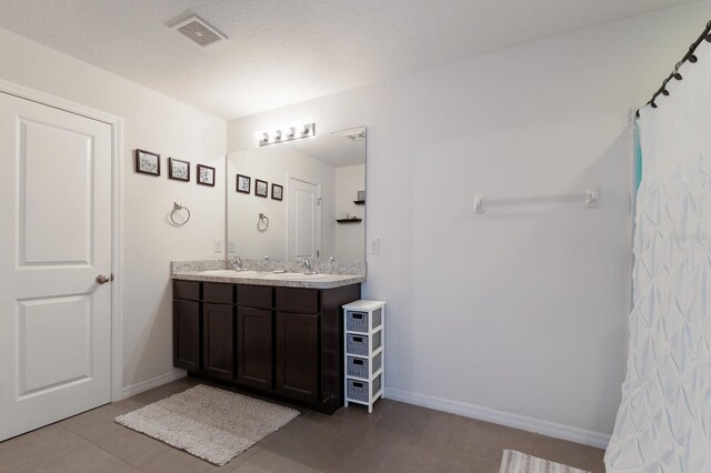 bathroom featuring dual bowl vanity and tile flooring