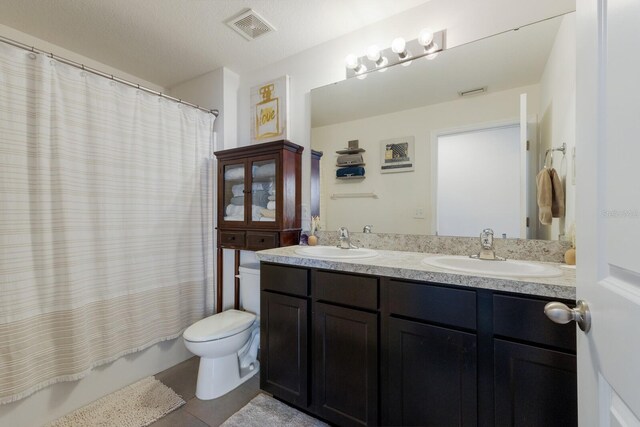 full bathroom with dual vanity, toilet, tile flooring, a textured ceiling, and shower / tub combo with curtain