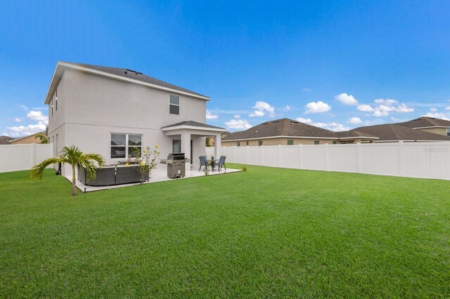 rear view of house featuring a yard, outdoor lounge area, and a patio area