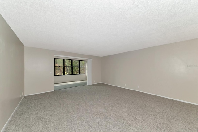 carpeted empty room with a textured ceiling