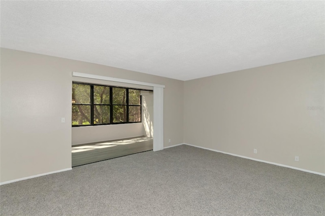 carpeted spare room featuring a textured ceiling