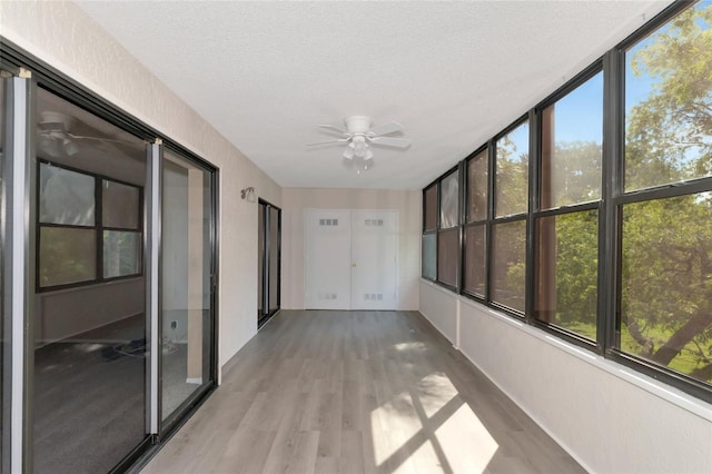 unfurnished sunroom featuring ceiling fan