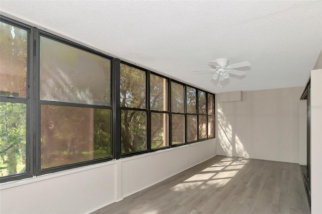 unfurnished sunroom featuring ceiling fan