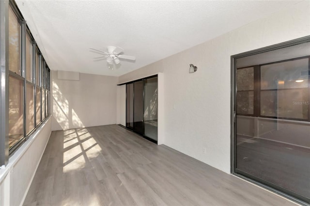 unfurnished sunroom featuring ceiling fan