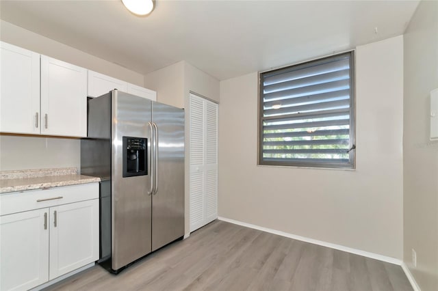 kitchen featuring light hardwood / wood-style floors, stainless steel fridge with ice dispenser, and white cabinetry