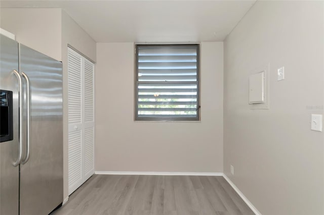 interior space with light wood-type flooring and stainless steel fridge with ice dispenser