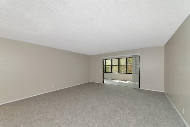 carpeted empty room featuring a textured ceiling