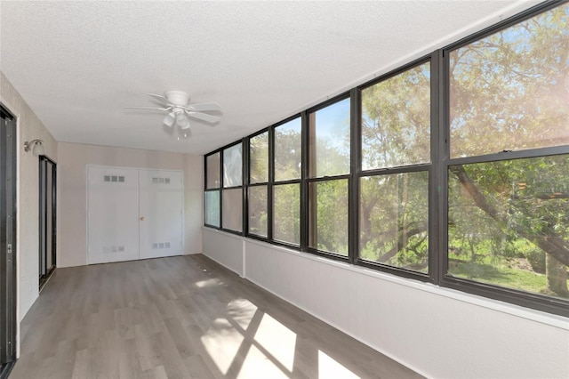 unfurnished sunroom featuring ceiling fan