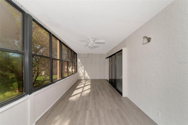 unfurnished sunroom featuring ceiling fan