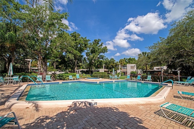 view of swimming pool with a patio and a hot tub