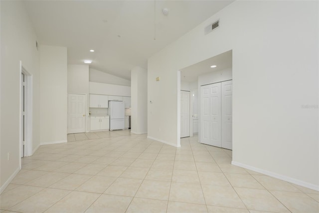 tiled empty room with vaulted ceiling