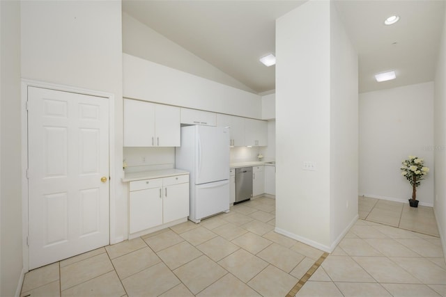 kitchen with light tile patterned flooring, stainless steel dishwasher, white fridge, vaulted ceiling, and white cabinets