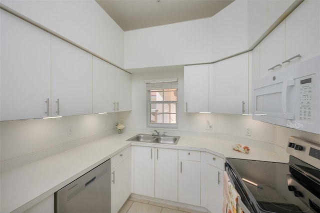 kitchen featuring sink, white cabinetry, stainless steel appliances, and light tile patterned floors