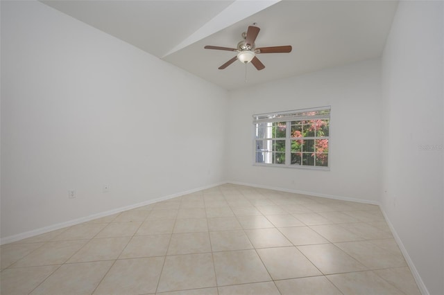 tiled spare room with ceiling fan and vaulted ceiling