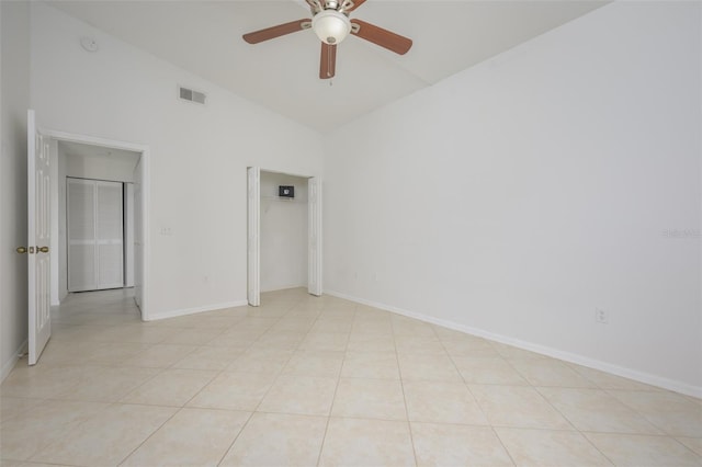 tiled empty room with ceiling fan and lofted ceiling