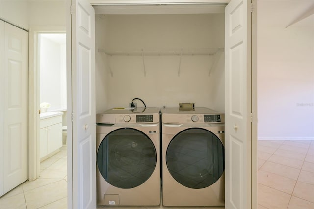 washroom with light tile patterned flooring and washing machine and clothes dryer