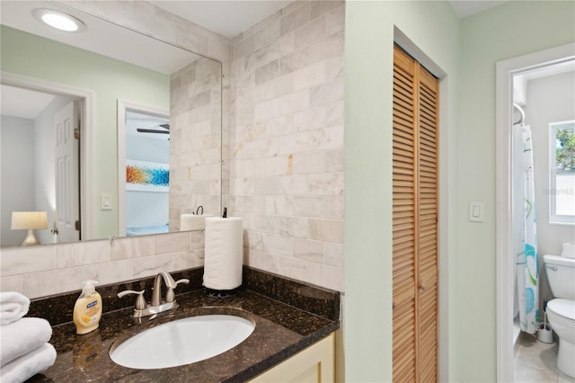 bathroom featuring vanity, toilet, backsplash, and walk in shower