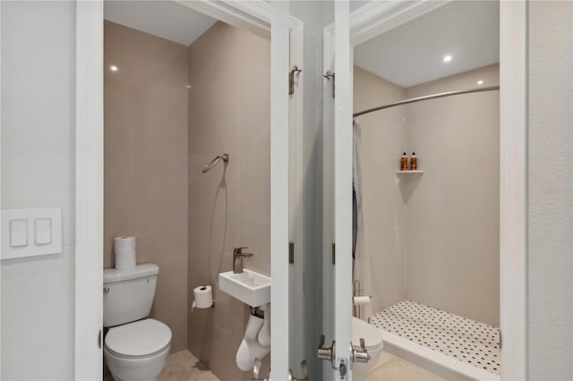 bathroom featuring tile patterned floors, toilet, walk in shower, and sink