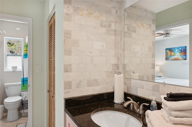 bathroom with decorative backsplash, ceiling fan, vanity, and toilet