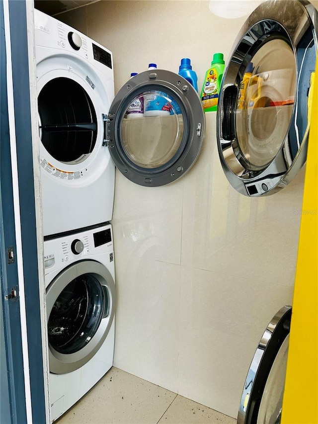 clothes washing area with stacked washer and clothes dryer