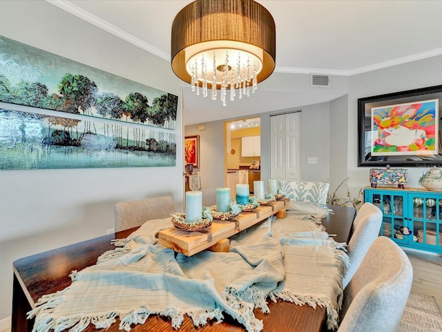 dining area with ornamental molding, wood-type flooring, and a notable chandelier