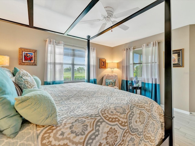 bedroom featuring multiple windows, ceiling fan, and light wood-type flooring