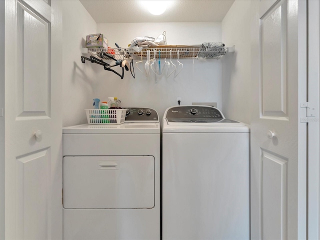 laundry area with washer and dryer and a textured ceiling