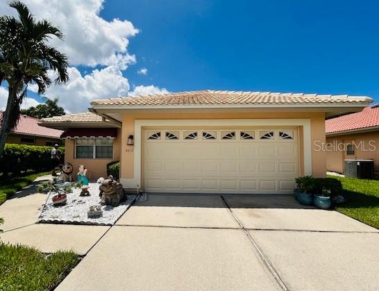 view of front of house featuring a tiled roof, concrete driveway, an attached garage, and stucco siding